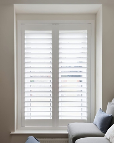 Full Height PVC Plantation Shutters for Office Waiting Room Full height white PVC plantation shutters fitted in an office waiting room, providing privacy and light control.