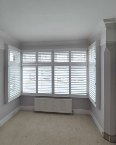 Box Bay Window PVC Shutters Fitted Outside Recess White PVC plantation shutters fitted to a box bay window, installed outside the recess due to limited window depth.