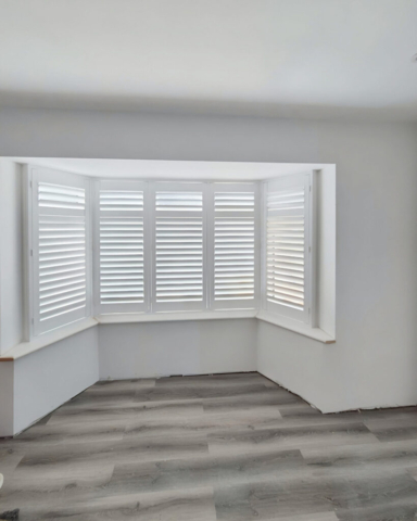 UK Made PVC Plantation Shutters for Angled Bay Window Beautifully fitted UK made white PVC plantation shutters installed in an angled bay window, custom made for a perfect fit.
