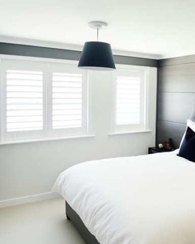 UK Made PVC Plantation Shutters for Bedroom in Manchester Beautifully fitted UK made white PVC plantation shutters installed in a bedroom by Scarlet Blinds in Manchester, custom made for a perfect fit.