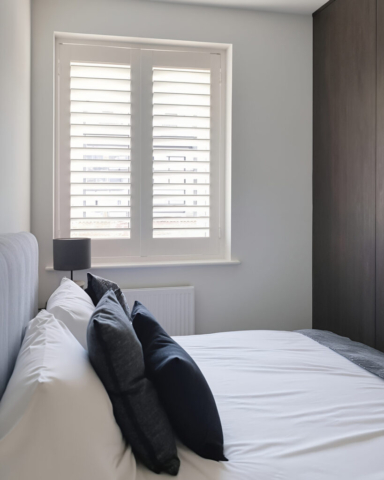 UK Made PVC Plantation Shutters for Bedroom in Manchester Beautifully fitted UK made white PVC plantation shutters installed in another bedroom by Scarlet Blinds in Manchester, custom made for a perfect fit.