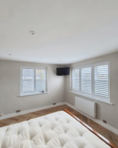 UK Made PVC Plantation Shutters for Two Bedroom Windows Beautifully fitted UK made white PVC plantation shutters installed on two bedroom windows by Scarlet Blinds in Manchester, custom made for a perfect fit.