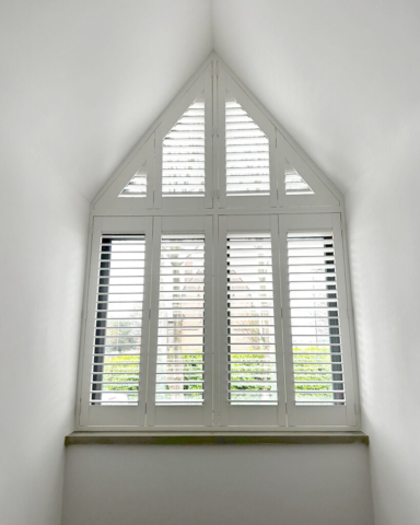 UK Made PVC Plantation Shutters for Arched Window in Manchester Arched window fitted with UK made white PVC plantation shutters by Scarlet Blinds in Manchester, custom made for special shapes and sizes.