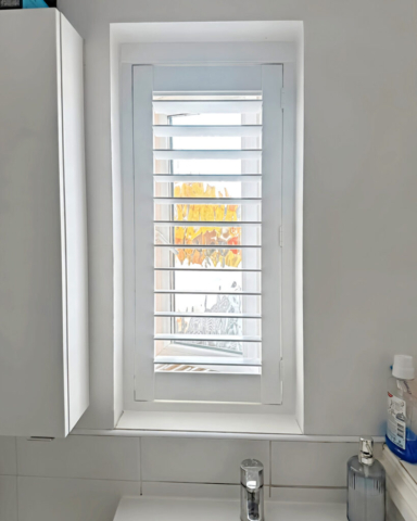 Small PVC Plantation Shutter for Family Bathroom Window Small white PVC plantation shutter fitted to a family bathroom window, providing privacy and moisture resistance.