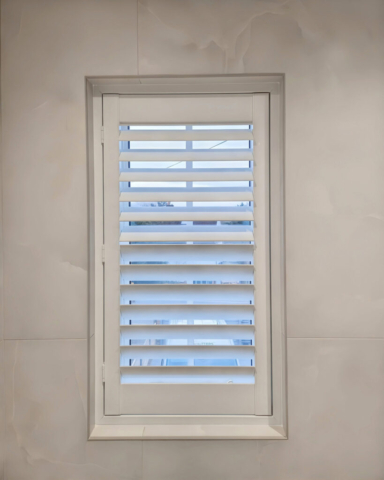 PVC Plantation Shutter Fitted in Bathroom White PVC plantation shutter fitted in a bathroom, moisture resistant and ideal for humid environments.