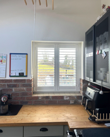 UK Made PVC Plantation Shutters for Kitchen Window Beautifully fitted UK made white PVC plantation shutters installed on a kitchen window by Scarlet Blinds in Manchester, custom made for a perfect fit.