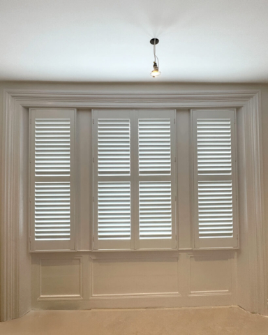 UK Made PVC Plantation Shutters for Three Panel Bay Window in Middleton Bay window with three different panels fitted with UK made white PVC plantation shutters by Scarlet Blinds and Shutters in Middleton, custom made for a perfect fit.