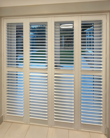 White PVC Plantation Shutters on Patio Doors by Scarlet Blinds and Shutters Angled view of white PVC plantation shutters fitted to a patio door by Scarlet Blinds and Shutters