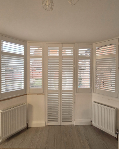Strato White PVC Plantation Shutters in Conservatory Strato white PVC plantation shutters installed in a bright conservatory, providing light control and privacy
