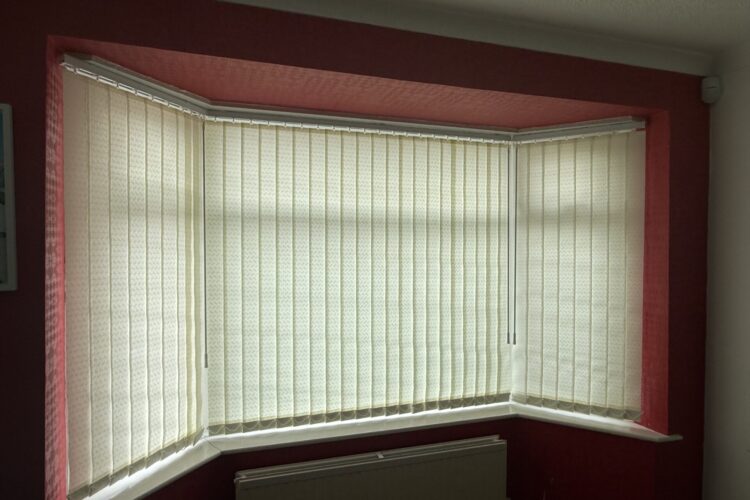 89mm dolphin cream vertical blinds closed in a bay window in Droylsden Manchester